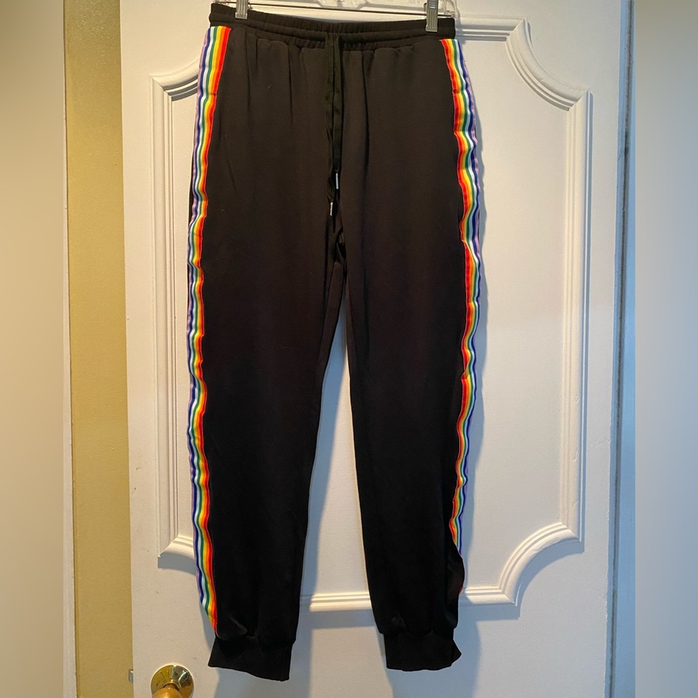 Black track pants with rainbow stripes on sides of legs